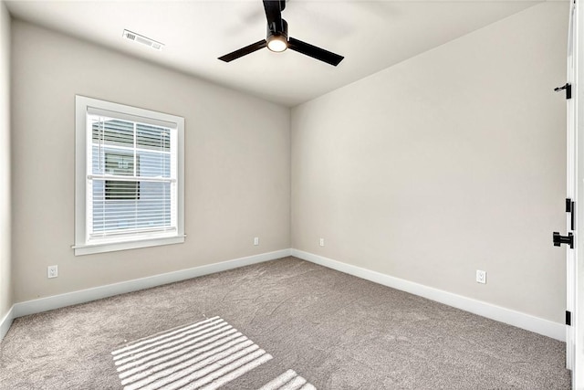 spare room featuring light colored carpet and ceiling fan