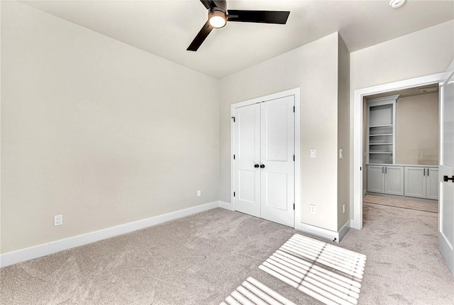 unfurnished bedroom featuring ceiling fan, a closet, and light colored carpet