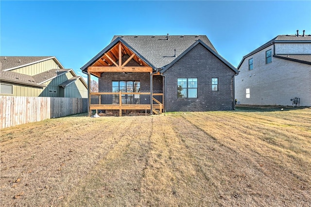 back of house featuring a lawn and a deck