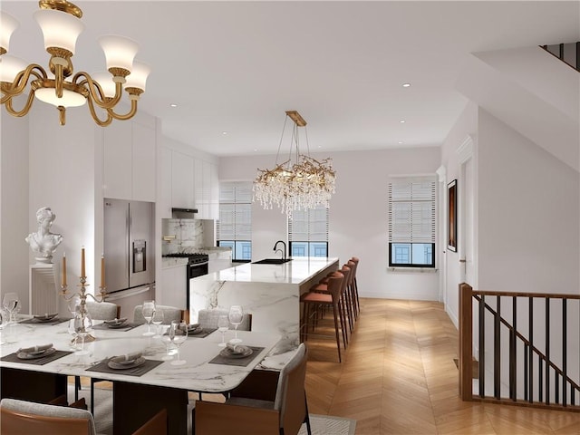 dining area featuring sink, light parquet floors, and a notable chandelier