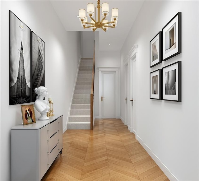 hall with light parquet floors and a chandelier