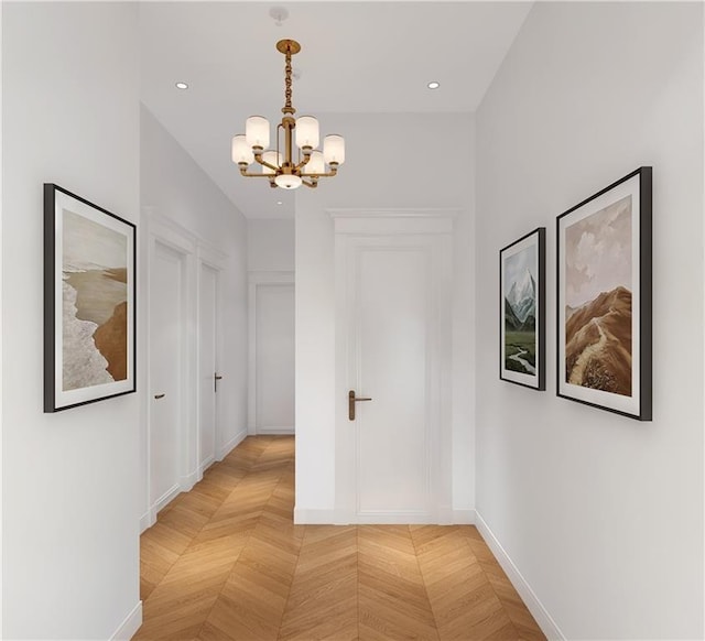 corridor with light parquet flooring and a notable chandelier