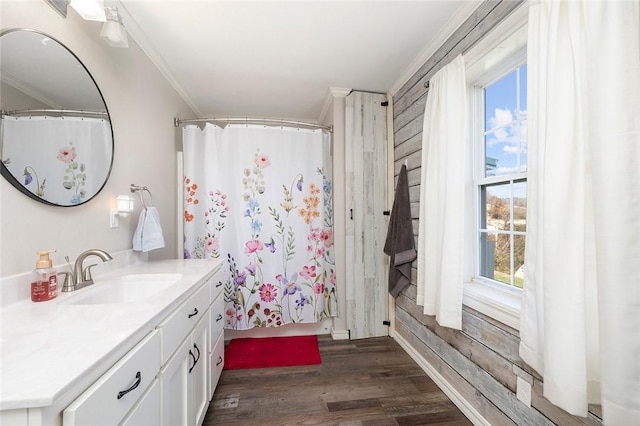 bathroom featuring hardwood / wood-style floors, plenty of natural light, crown molding, and vanity