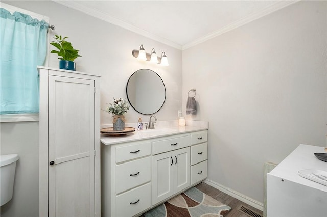 bathroom featuring vanity, hardwood / wood-style flooring, toilet, and ornamental molding