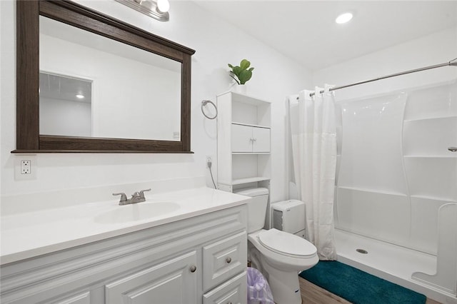 bathroom with a shower with shower curtain, vanity, and toilet