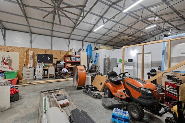 garage featuring washing machine and clothes dryer and stainless steel refrigerator