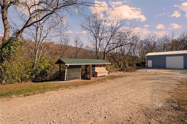 yard at dusk with a garage and an outdoor structure