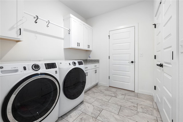 washroom featuring cabinets and washer and clothes dryer