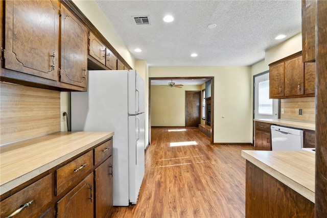 kitchen featuring a textured ceiling, ceiling fan, light hardwood / wood-style flooring, and white appliances