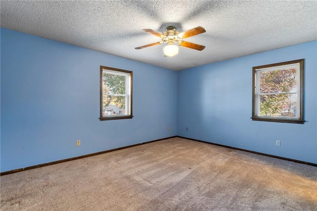 carpeted spare room featuring ceiling fan and a textured ceiling