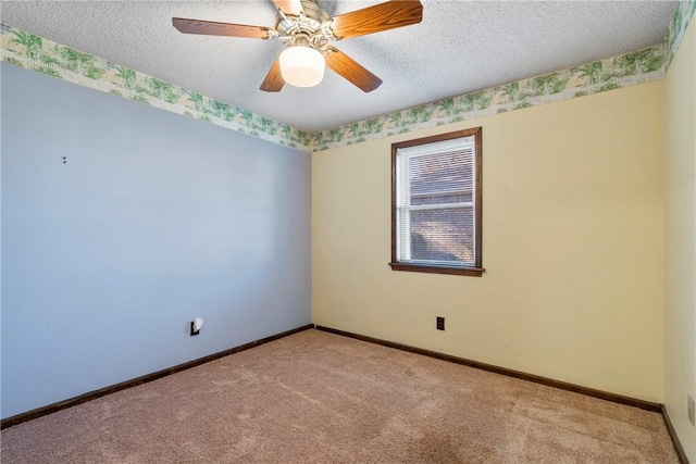 spare room with ceiling fan, a textured ceiling, and light carpet