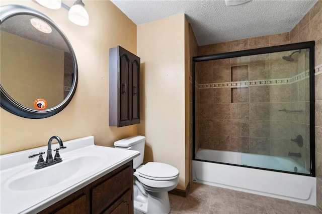 full bathroom featuring tile patterned floors, a textured ceiling, vanity, shower / bath combination with glass door, and toilet