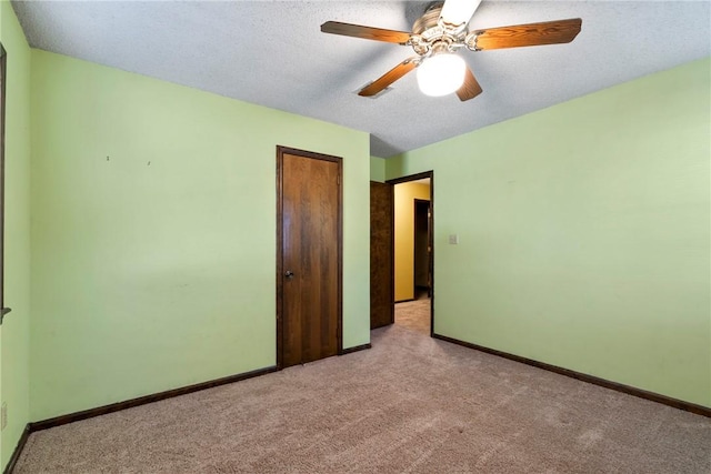 unfurnished bedroom featuring ceiling fan, light colored carpet, and a textured ceiling