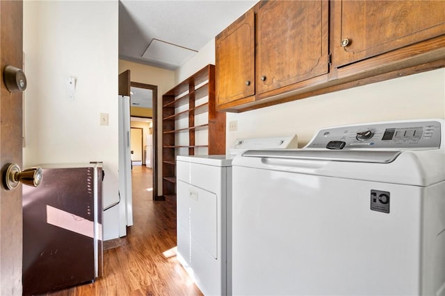 laundry room with cabinets, light hardwood / wood-style flooring, and washer and dryer