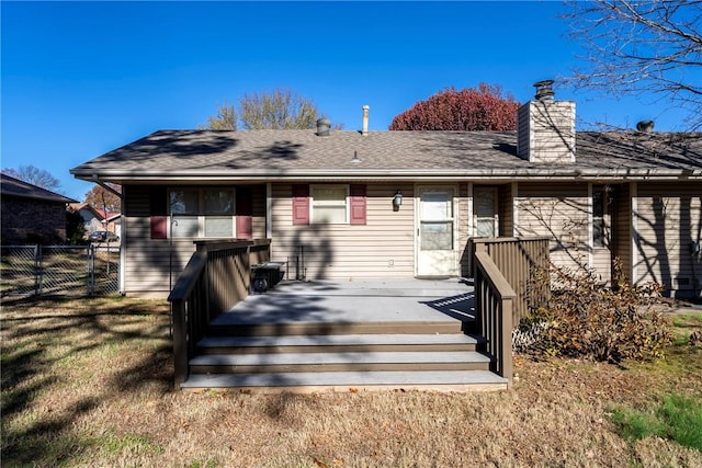 rear view of house featuring a lawn and a wooden deck