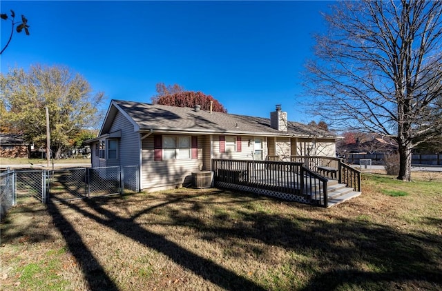 back of property with a yard and a wooden deck