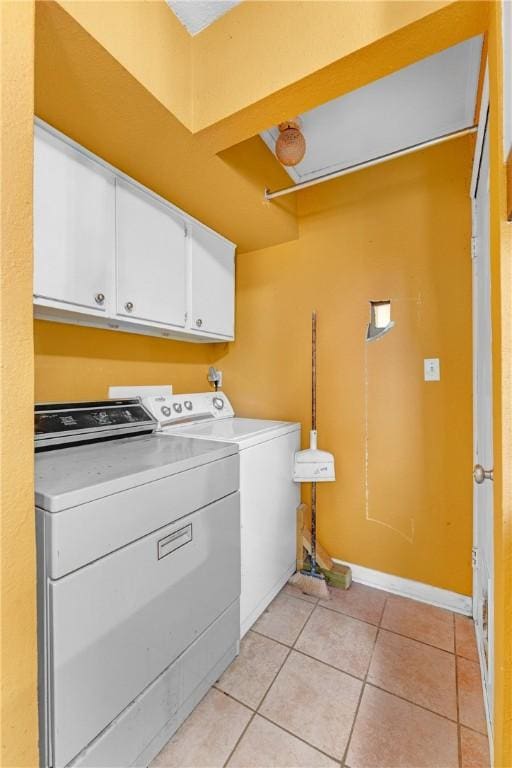 laundry area featuring cabinets, separate washer and dryer, and light tile patterned flooring