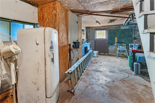 misc room featuring water heater and concrete flooring