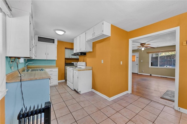 kitchen with sink, ceiling fan, light tile patterned floors, white electric range oven, and white cabinetry