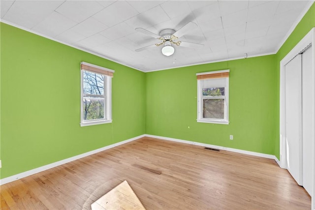 unfurnished bedroom featuring light hardwood / wood-style floors, ceiling fan, and crown molding