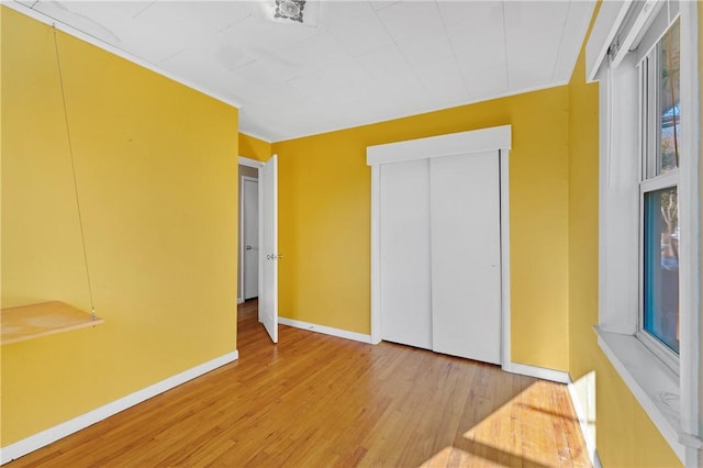 unfurnished bedroom with wood-type flooring and a closet