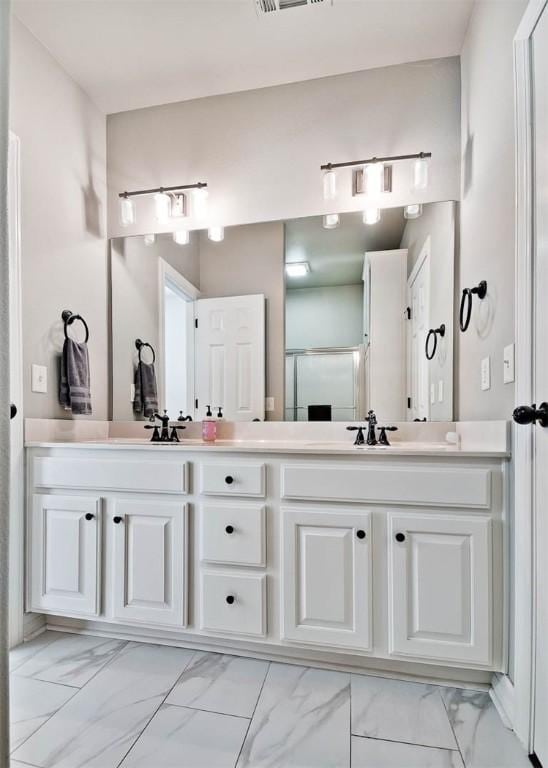 bathroom with vanity and a shower with door