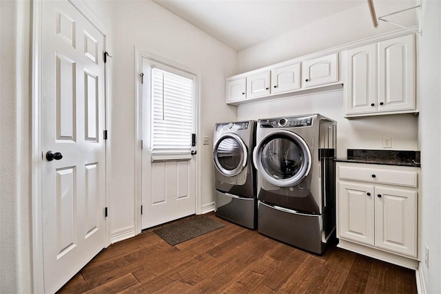 clothes washing area featuring washing machine and clothes dryer, cabinets, and dark hardwood / wood-style floors