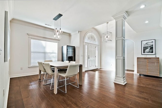 dining space with dark hardwood / wood-style flooring, ornamental molding, and a notable chandelier