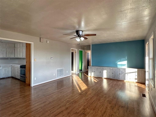 unfurnished living room with ceiling fan, wood-type flooring, and a textured ceiling