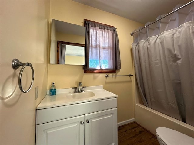 full bathroom featuring vanity, wood-type flooring, shower / tub combo with curtain, and toilet