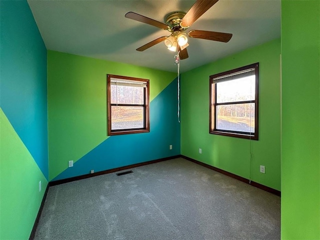 unfurnished room with ceiling fan, a healthy amount of sunlight, and carpet