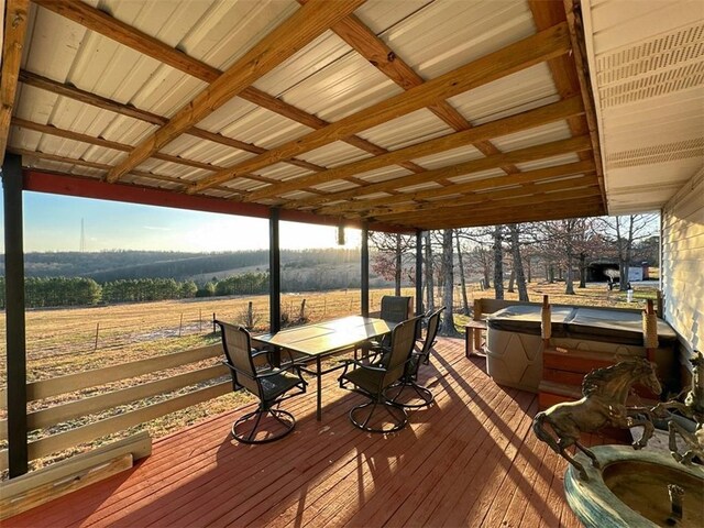 wooden terrace featuring a rural view and a hot tub