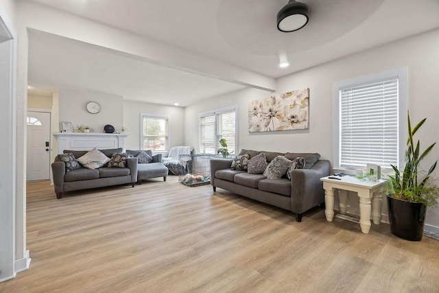 living room featuring beam ceiling and light hardwood / wood-style flooring