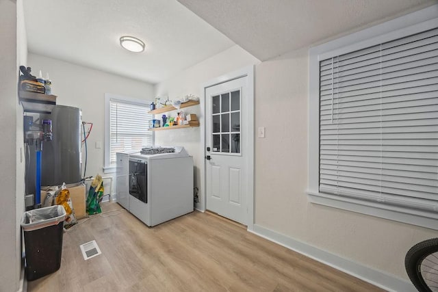 laundry area with light hardwood / wood-style floors and washing machine and dryer