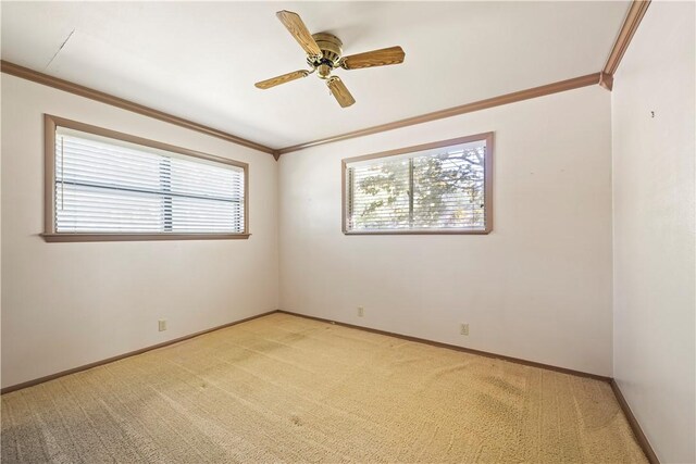 spare room featuring crown molding, light colored carpet, and ceiling fan