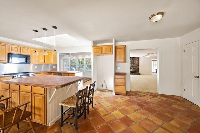 kitchen featuring stainless steel appliances, plenty of natural light, a breakfast bar, and pendant lighting