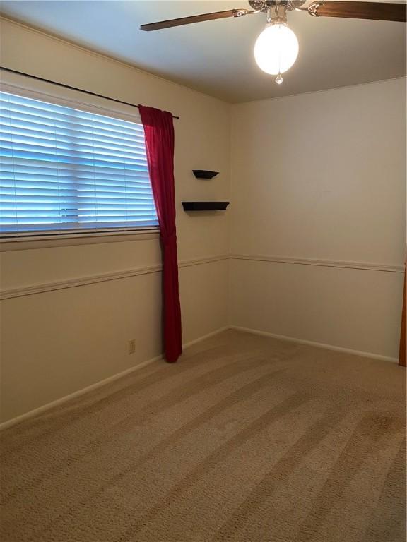 spare room featuring ceiling fan and carpet