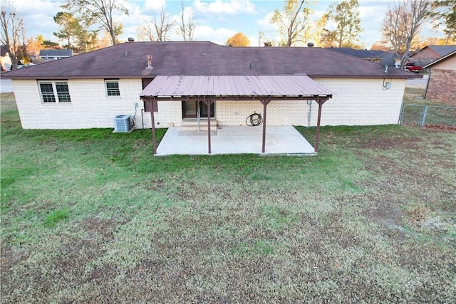 rear view of property with a yard, a patio, and central air condition unit