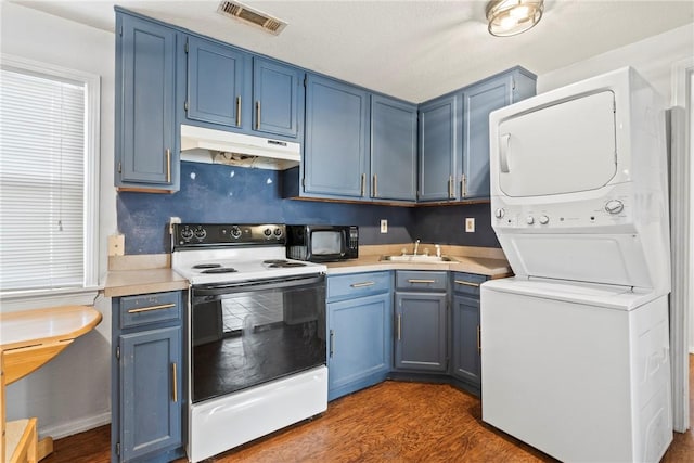 kitchen with dark hardwood / wood-style flooring, sink, blue cabinetry, electric range, and stacked washer and dryer