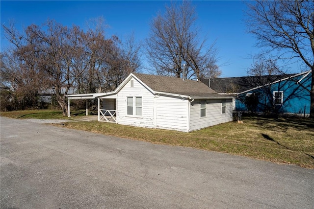 view of home's exterior featuring a carport and a yard