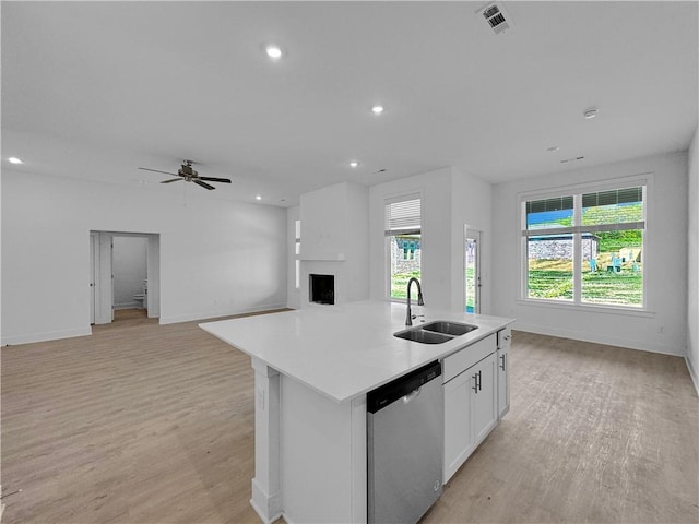 kitchen featuring white cabinets, a kitchen island with sink, sink, light hardwood / wood-style flooring, and dishwasher