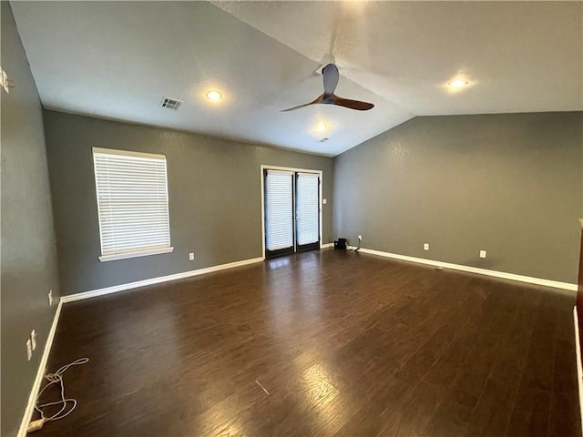 empty room featuring vaulted ceiling, ceiling fan, and dark wood-type flooring