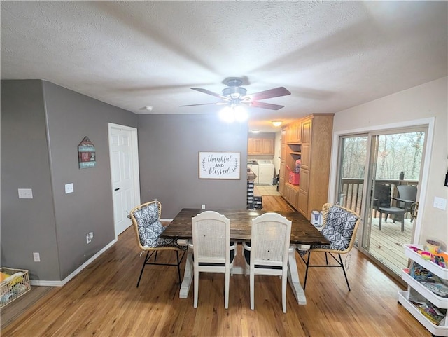 dining area with separate washer and dryer, light hardwood / wood-style floors, and a textured ceiling