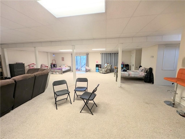 carpeted living room featuring a drop ceiling