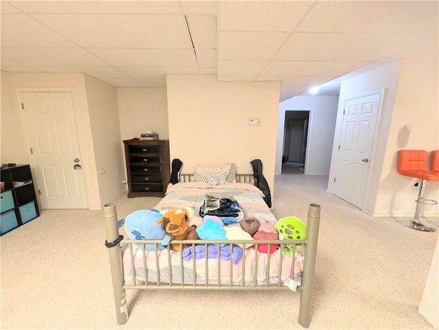 bedroom featuring carpet and a drop ceiling