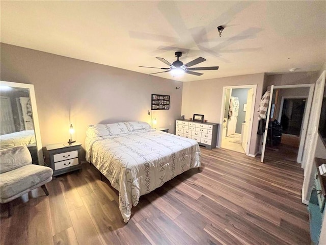 bedroom with connected bathroom, ceiling fan, and dark wood-type flooring