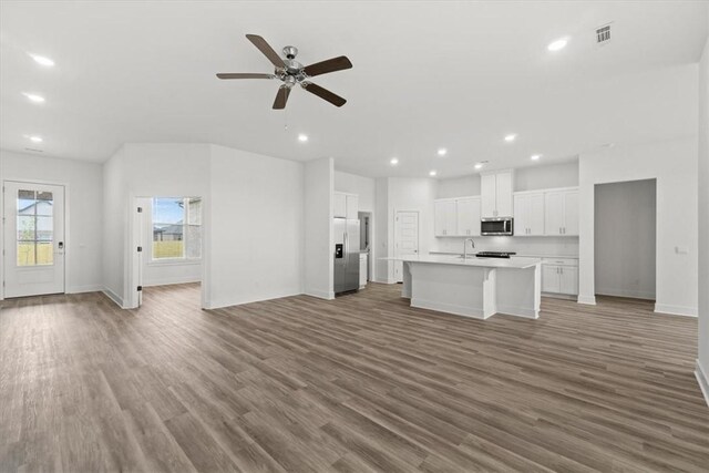 unfurnished living room with ceiling fan and wood-type flooring