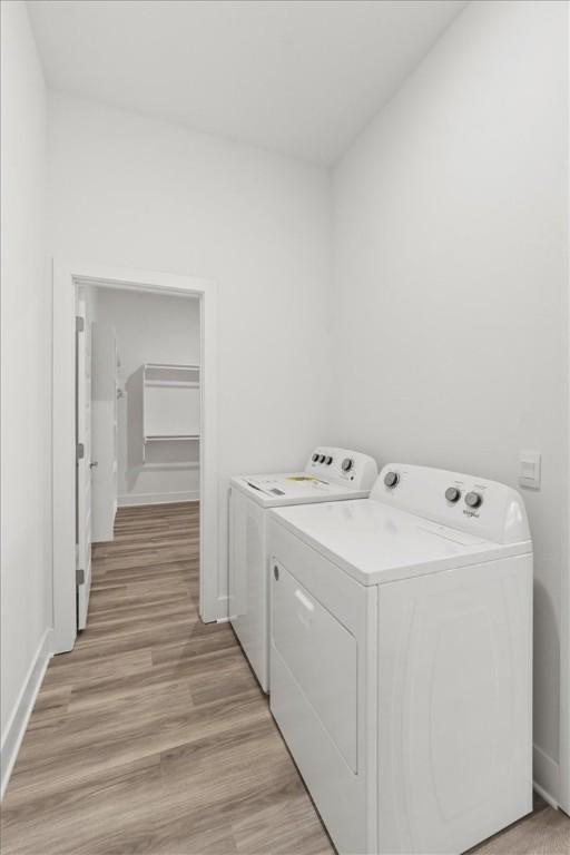 washroom with light wood-type flooring and washing machine and clothes dryer