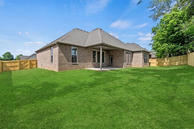 rear view of house featuring a yard and a patio area