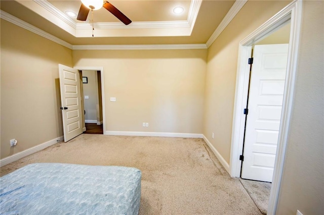 bedroom with carpet flooring, a tray ceiling, ceiling fan, and ornamental molding